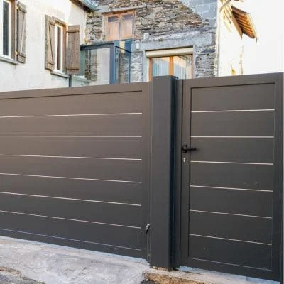 Dark gray horizontal slat driveway gate with stainless steel frame and hardware